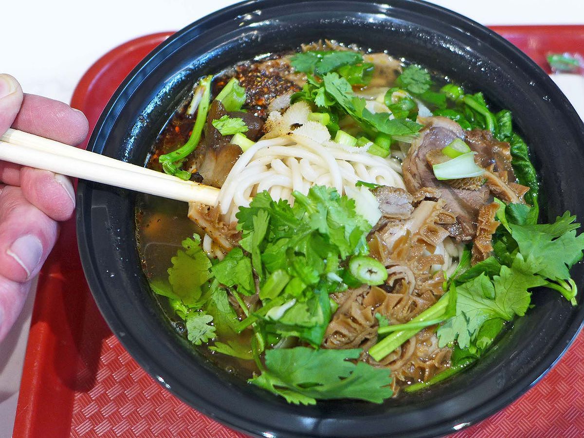 Bowl of soup with noodles and cilantro.