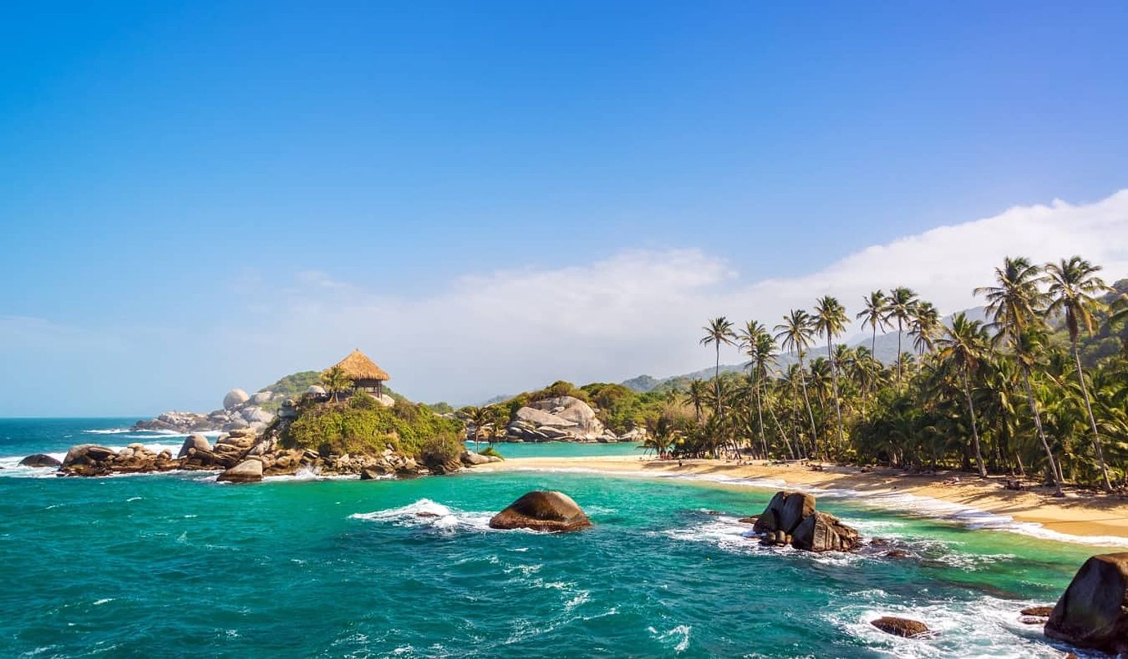 The turquoise waters, white sand beaches, and palm trees of Tayrona National Park in Colombia